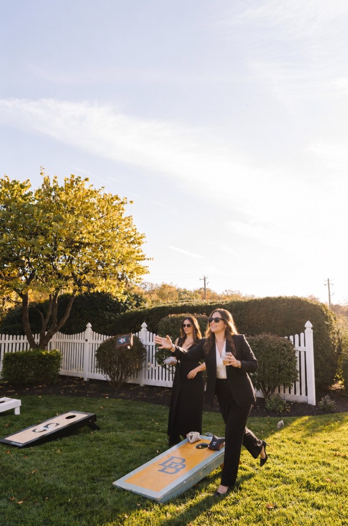 Guests playing Cornhole on a garden lawn